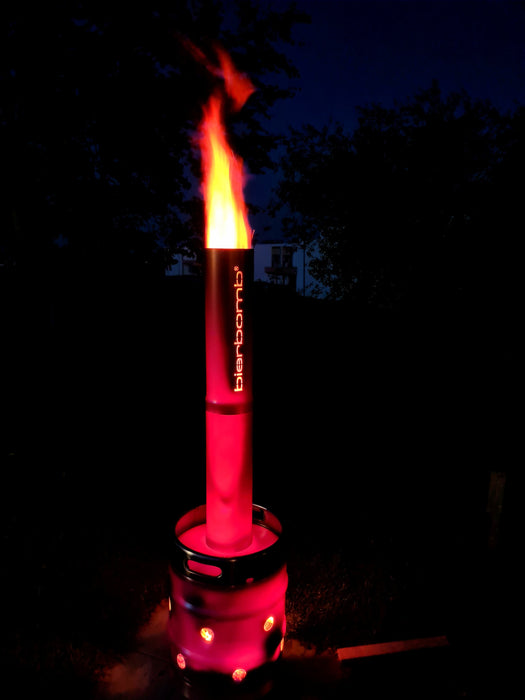 bierbomb® bei Nacht im Garten, das Rohr glüht rot, Flamme über dem Auslass
