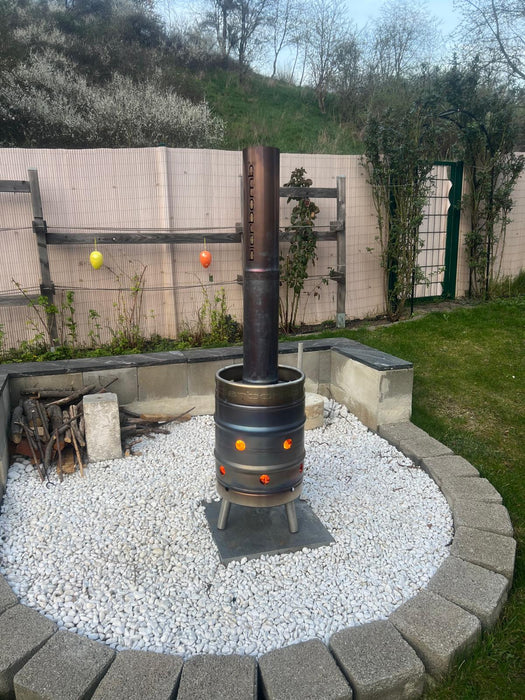 bierbomb® bei Tageslicht auf einem Kiesbett im Garten, Glut in den Luftlöchern